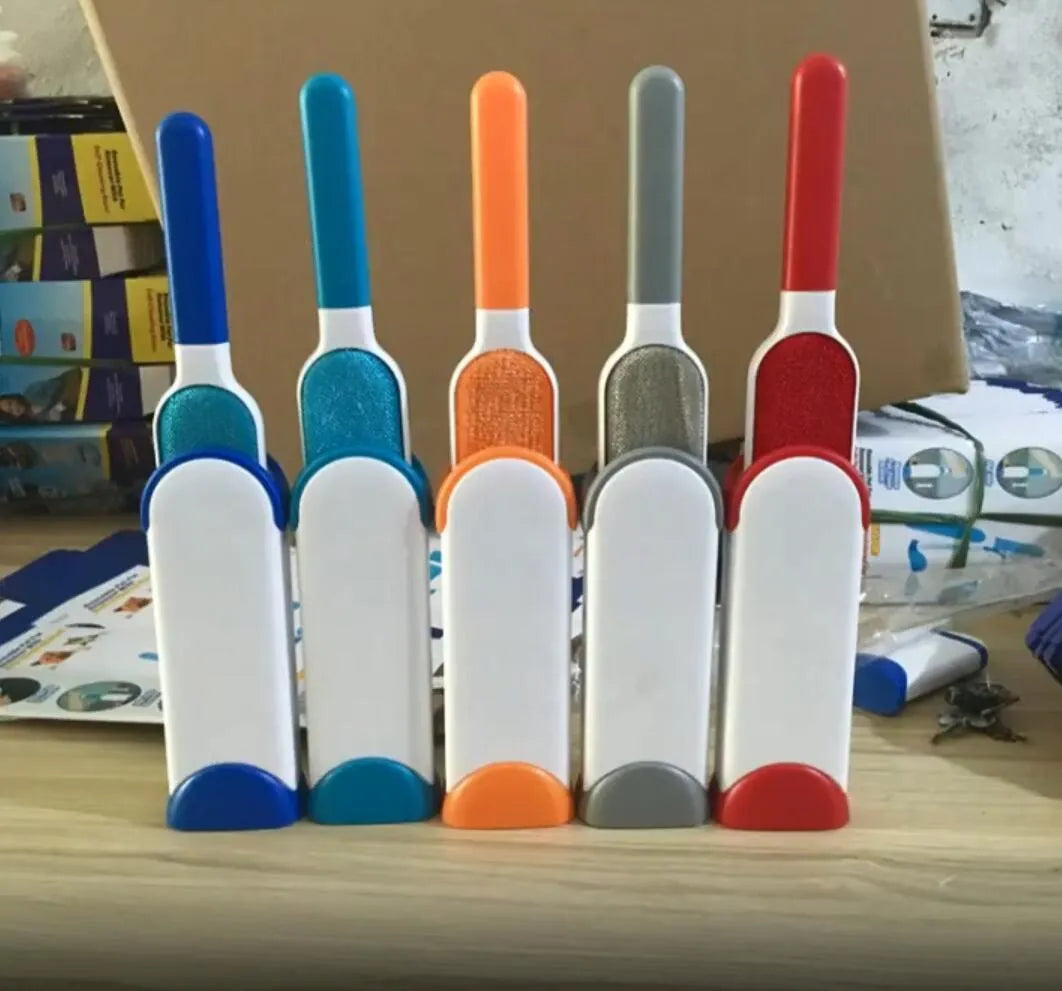 Blue reusable pet hair removal comb with double-sided brush head next to its self-cleaning base.