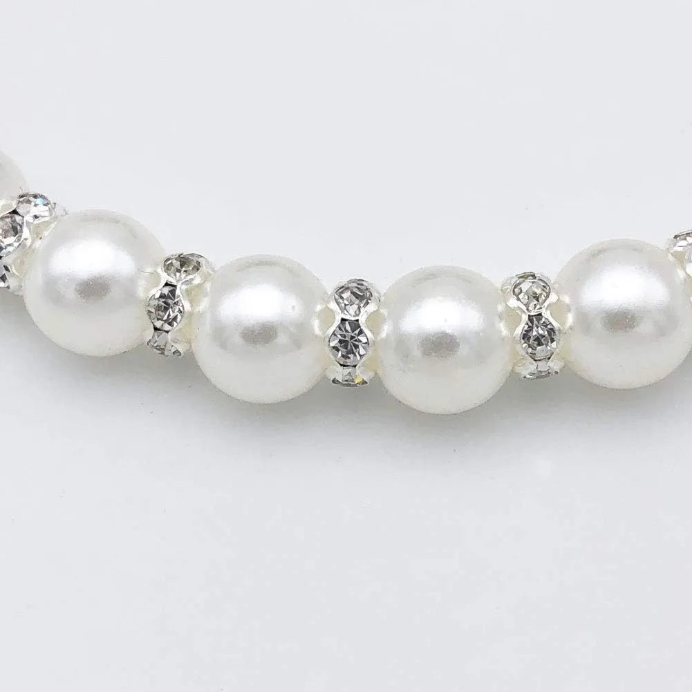 Small dog wearing adjustable pearl and rhinestone necklace with soft ribbon bow in blue colour