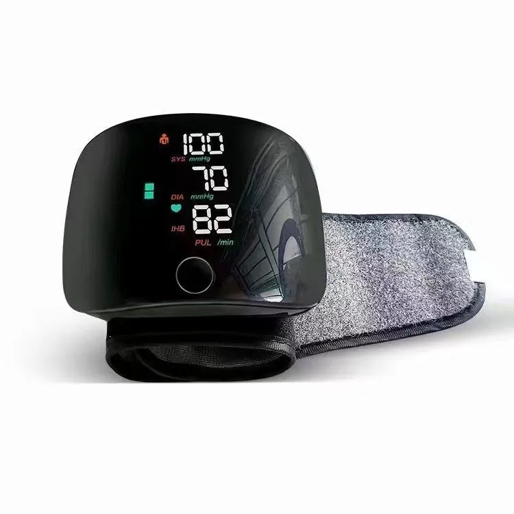 Black wrist blood pressure monitor with digital display and USB charging port.