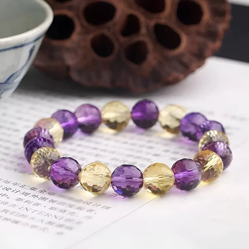 Handcrafted 128-facet crystal ametrine bracelet with detailed beads on a wrist.