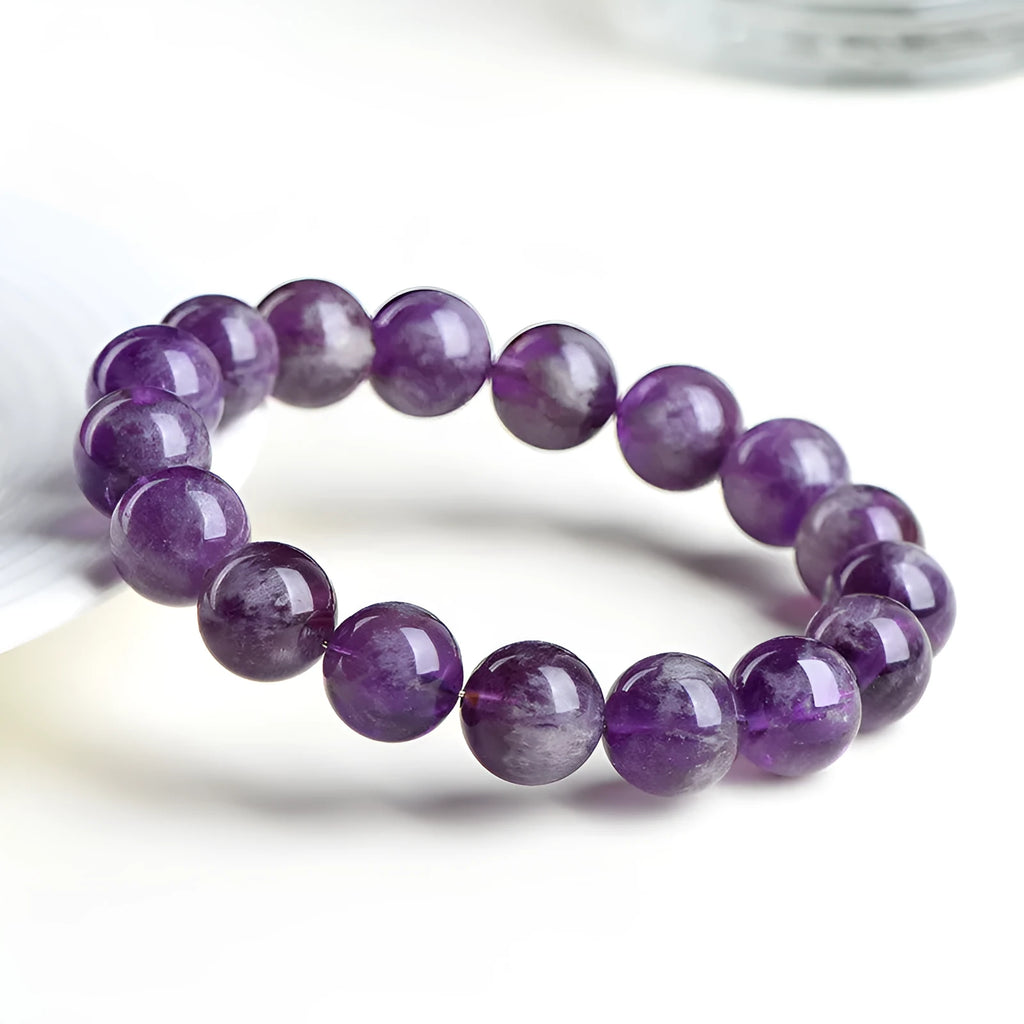 Natural Snow Mountain Purple Feather Amethyst crystal bracelet with scattered geometric beads featuring a Ruyi pattern.