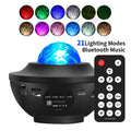 Black bowl-shaped star projection lamp with laser effects and Bluetooth connectivity on wooden desk