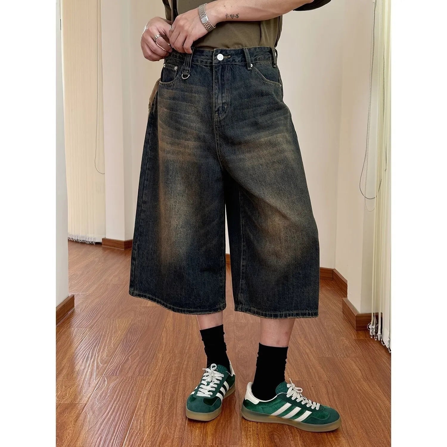 Men's loose straight-cut denim shorts in blue, shown on a hanger.