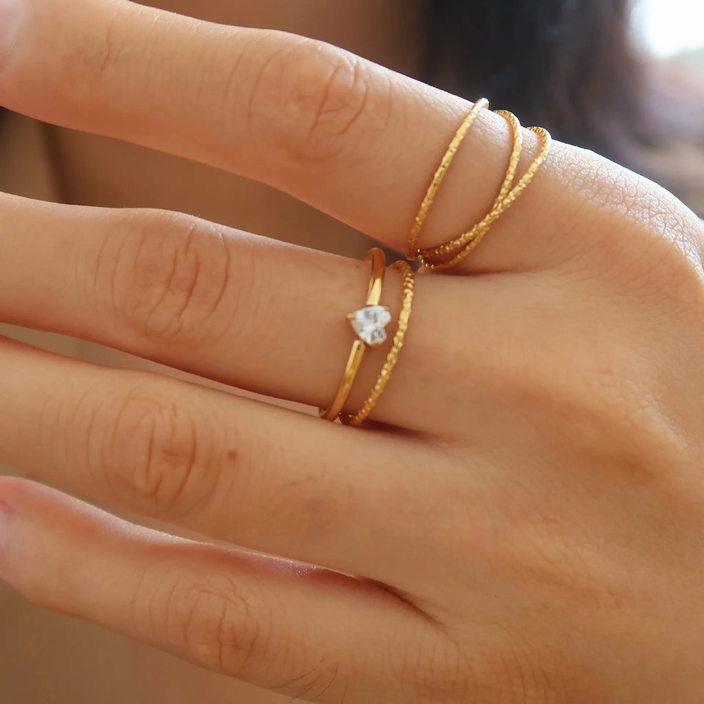 Golden heart-shaped stainless steel ring with love oval design on female hand