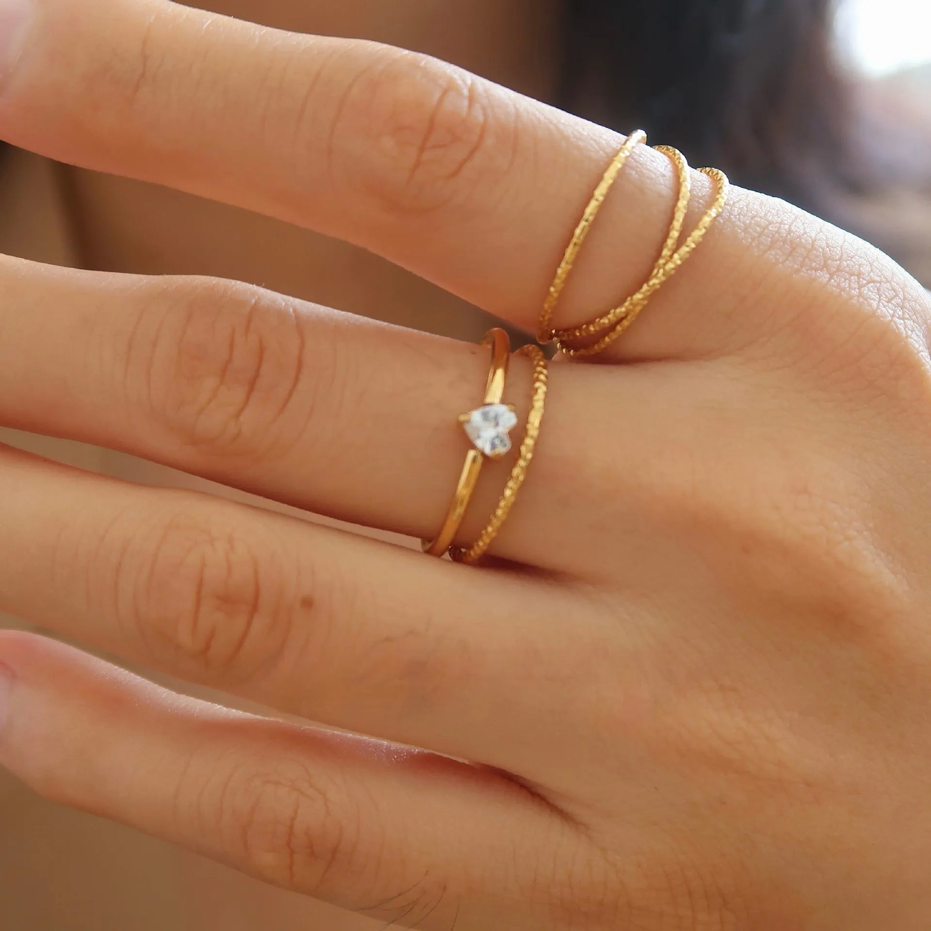 Golden heart-shaped stainless steel ring with love oval design on female hand