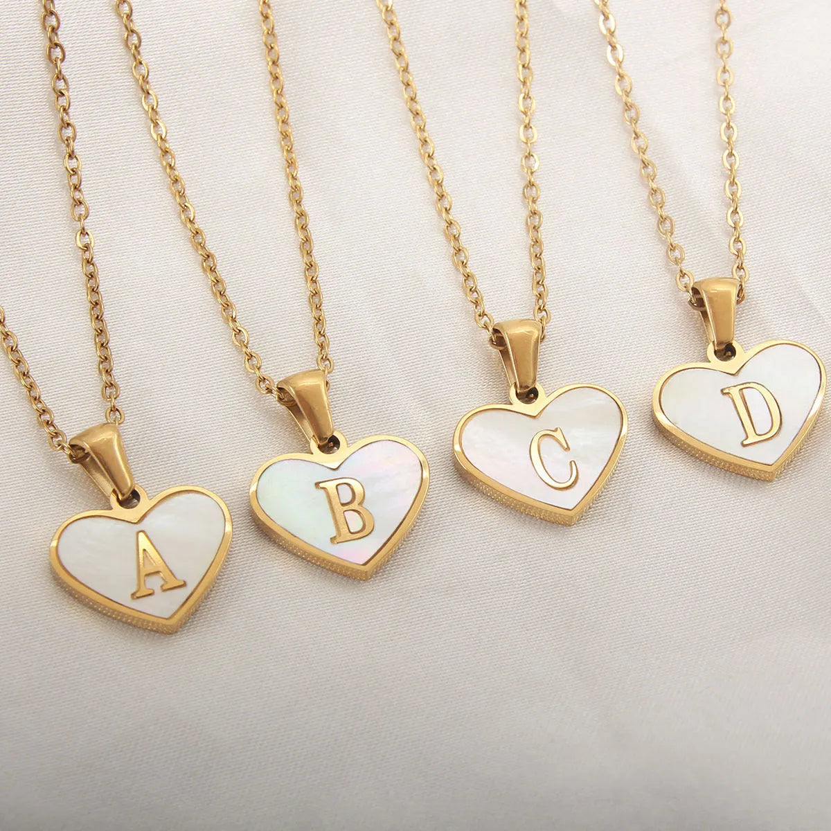 Gold heart necklace with white shell detail and personalised initial letter on adjustable chain