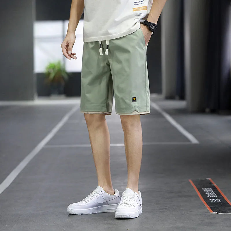 Men's loose-fit casual shorts in khaki colour with elastic waistband, shown on a neutral background.