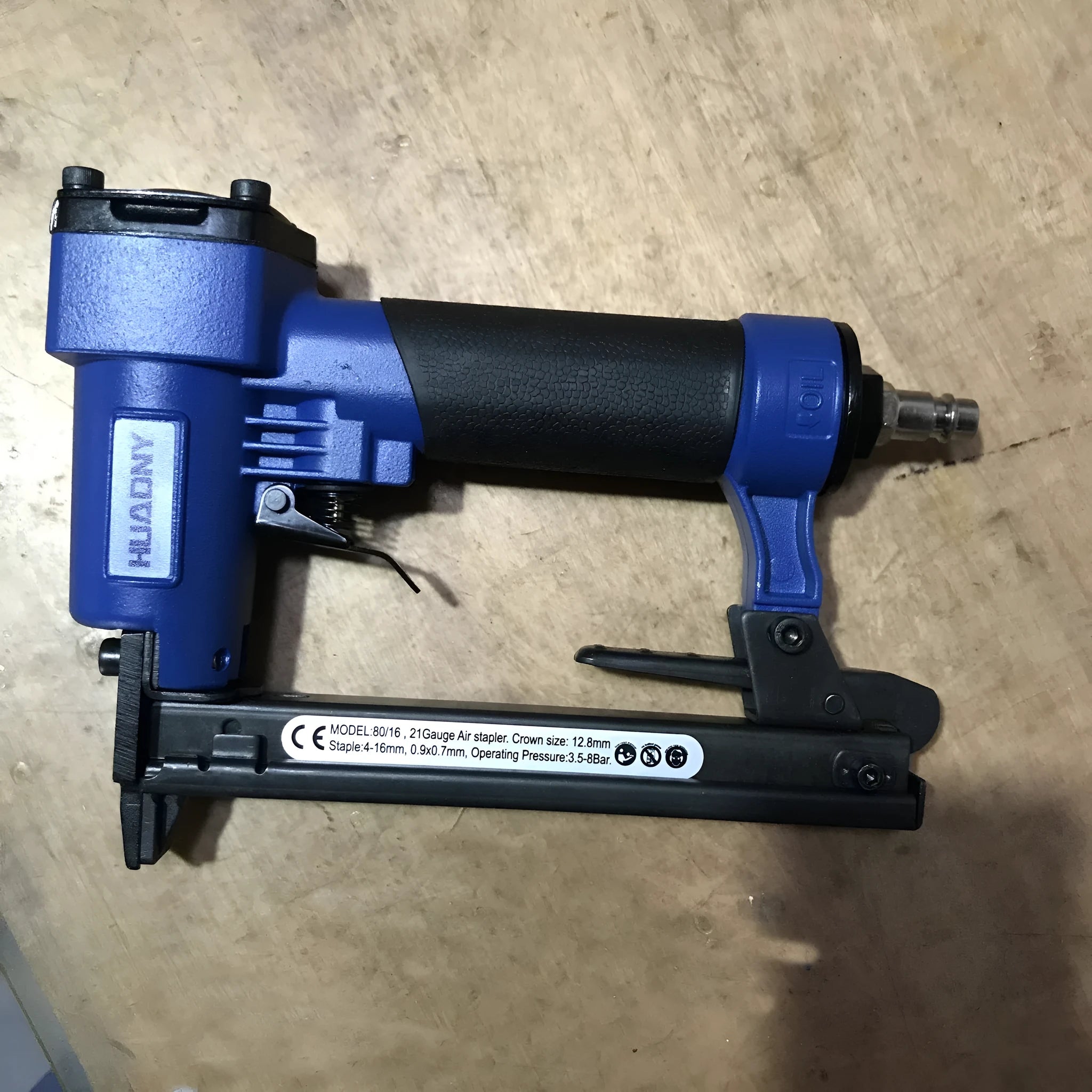 Blue and yellow U-type pneumatic strip nail gun for interior decoration and furniture work.