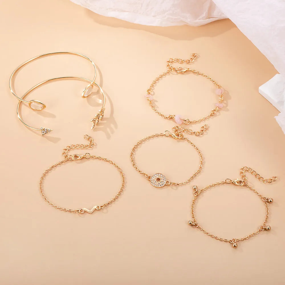 Golden bracelet charm set with six pieces including V-shape, arrow, water drop and drill spot designs