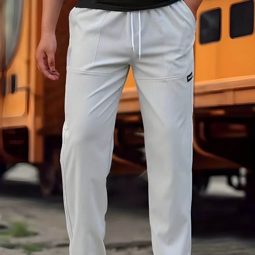 Men's polyester trousers for spring and autumn in light grey, shown flat.