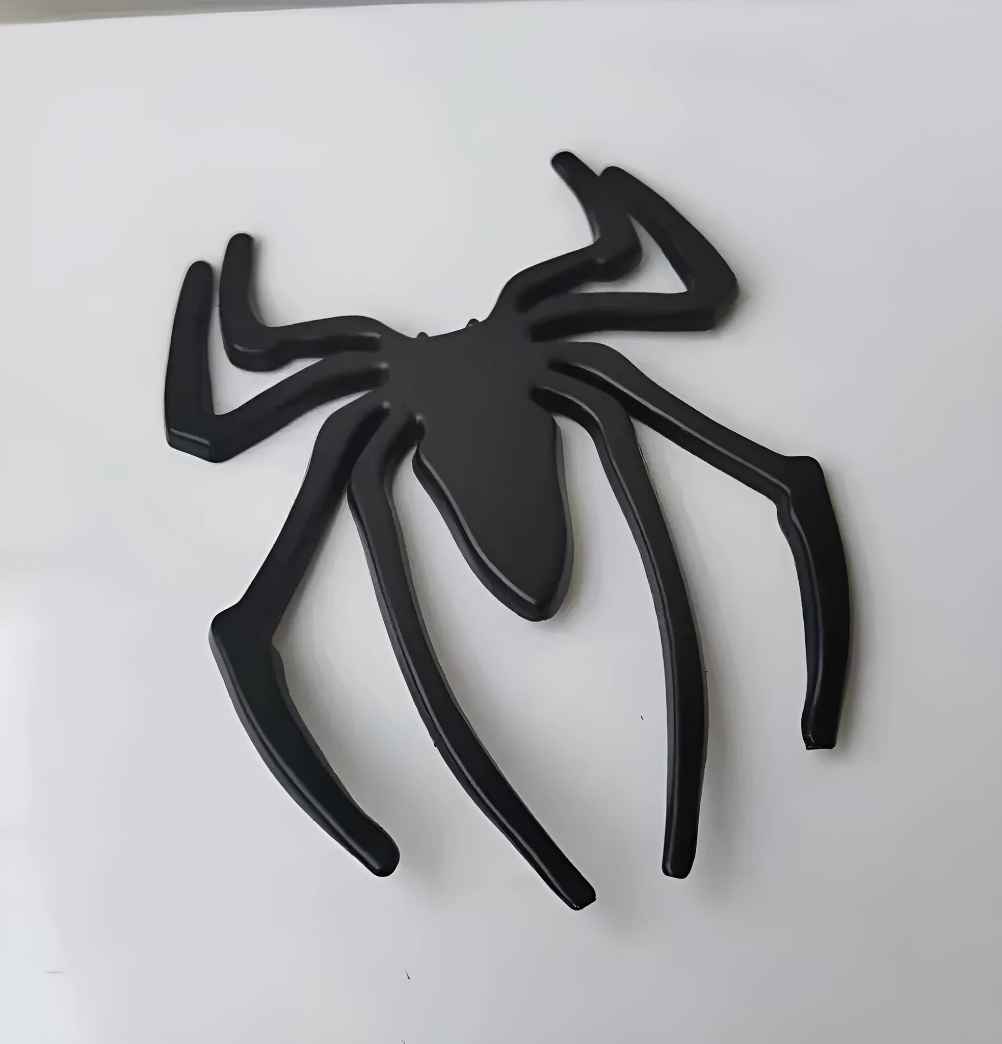 Three-dimensional metal spider bumper sticker in zinc alloy, showing detailed design