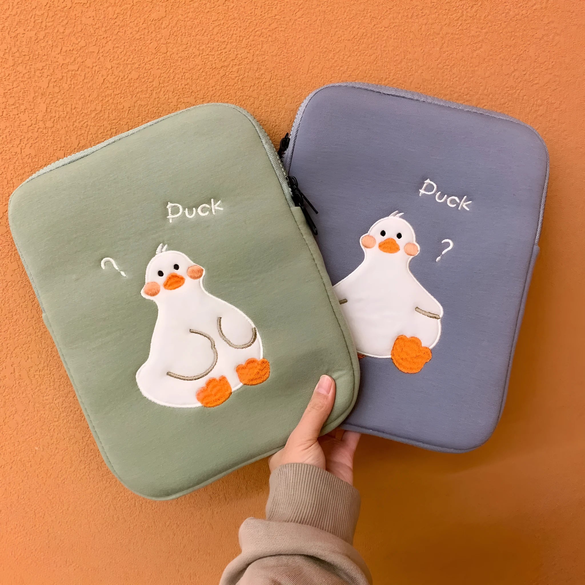 Blue cotton tablet case with embroidered cartoon duck design and zipper closure