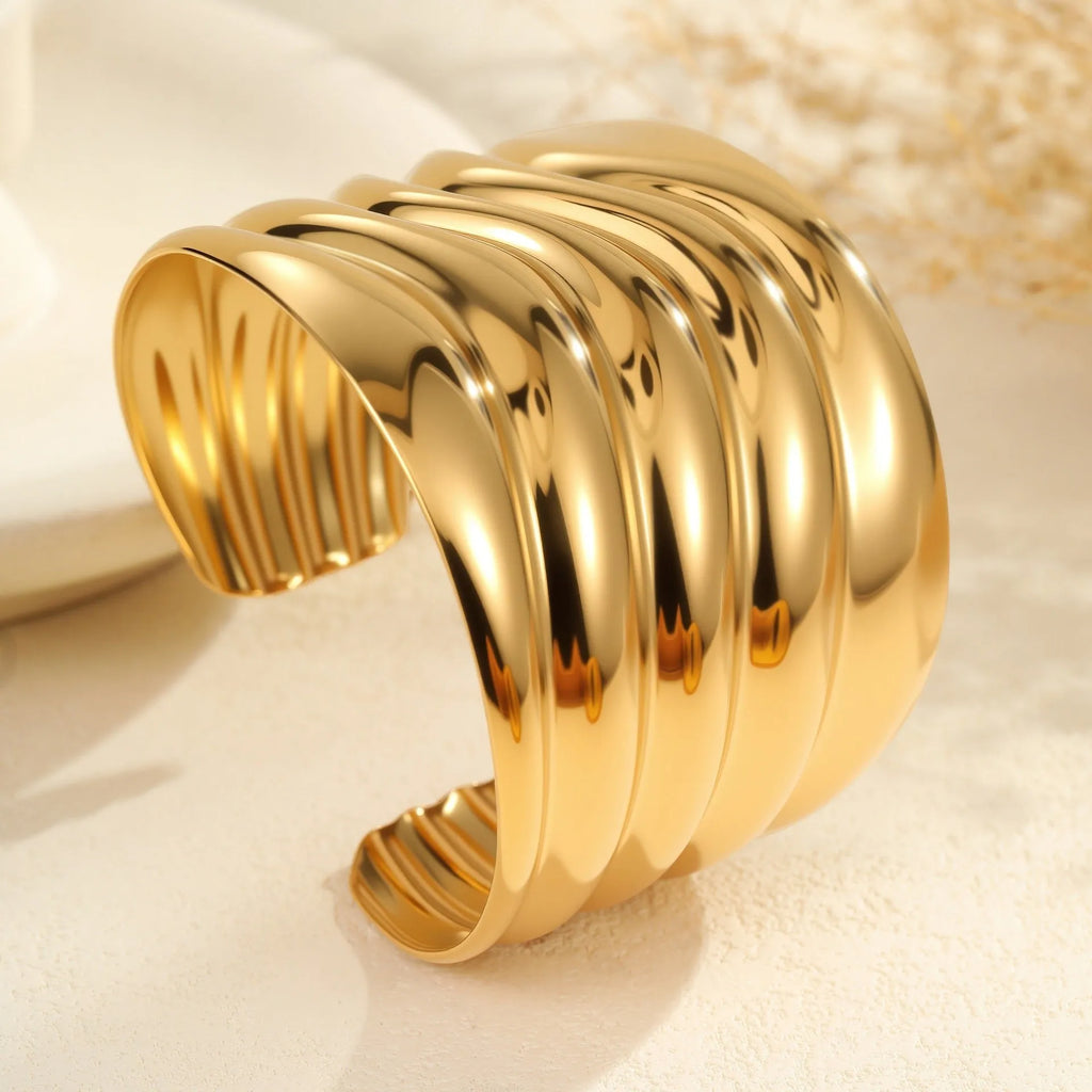 Women's wide cuff bracelet with gold plating and exaggerated niche opening in asymmetric wave design