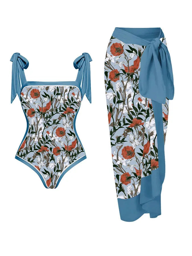 Women's floral print two-piece swimsuit with a blue chiffon skirt laid flat.