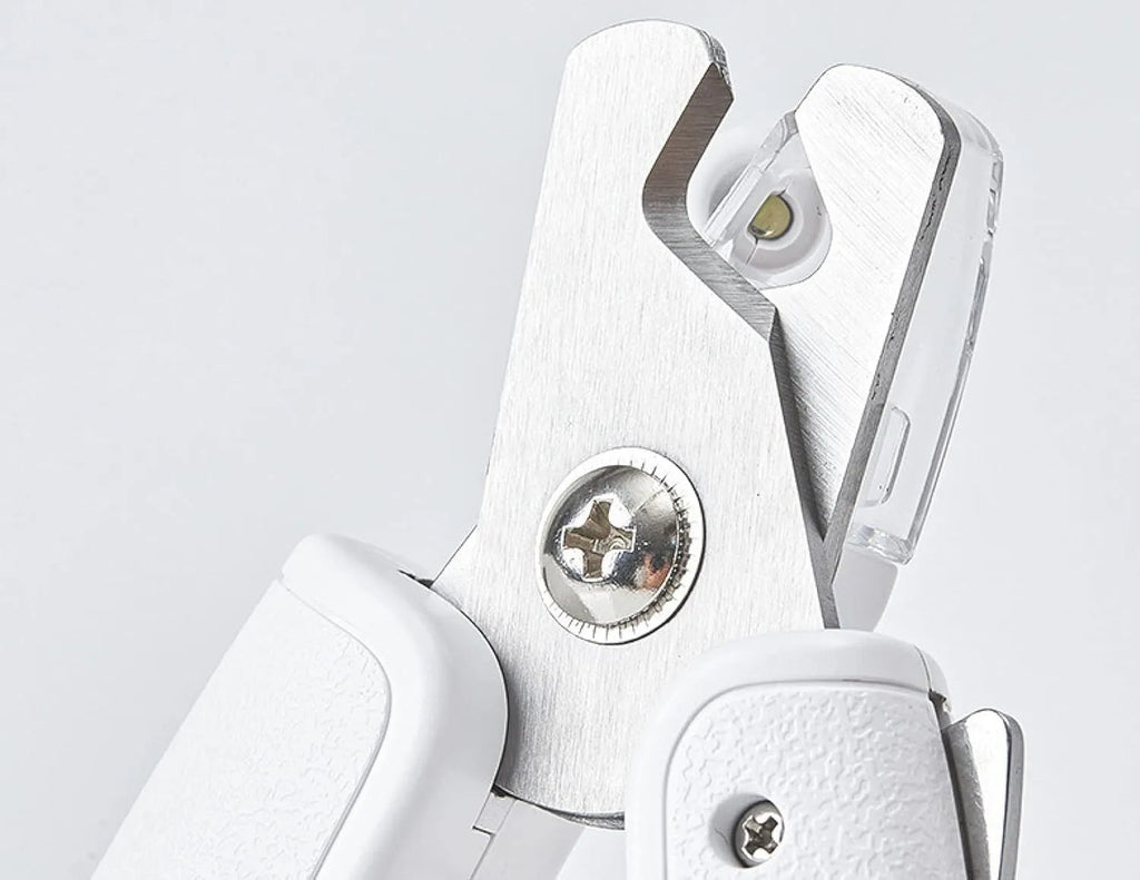 White pet nail clippers with LED light, transparent splash guard, and anti-slip handle.