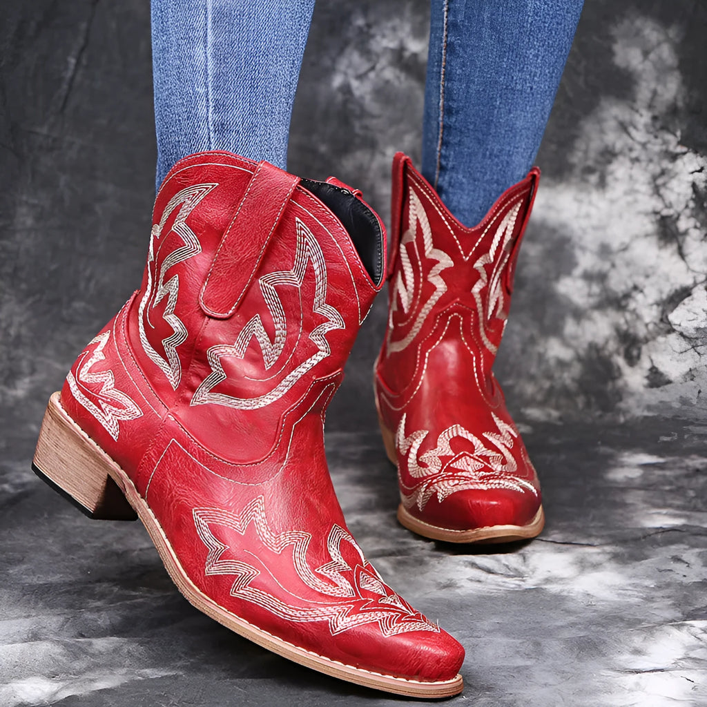 Blue women's cowboy boots with white embroidery, a low wedge heel, and a pointed toe