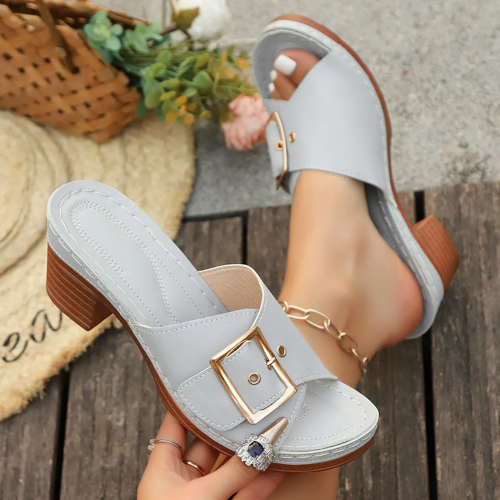 Women's black retro chunky heel slippers with a silver metal buckle closure on a round toe.