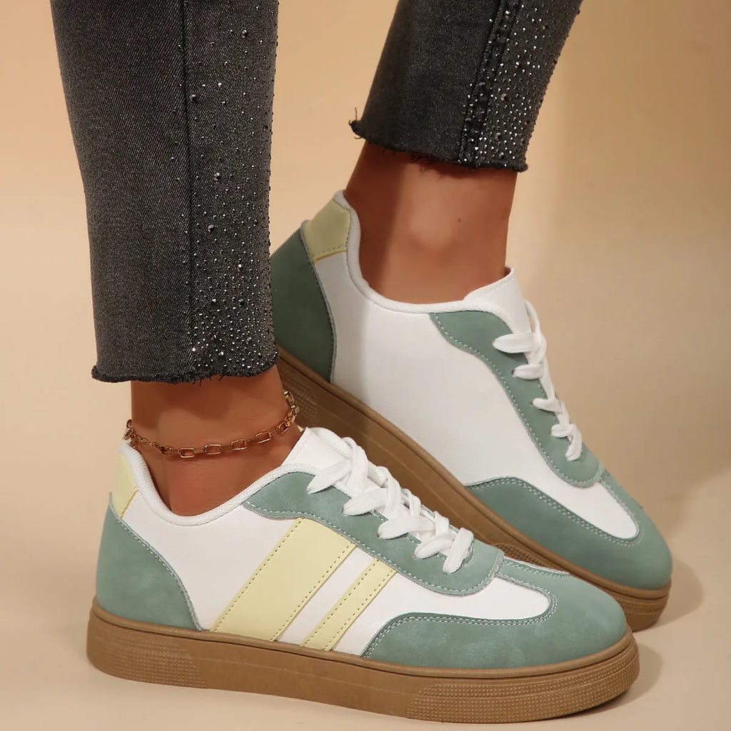 Women's retro sports shoes in white with green candy colour accents and cross-strap details on PU leather upper.