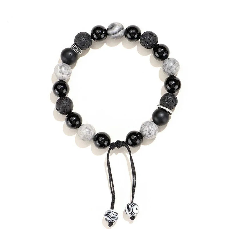 Black agate map stone and volcanic rock bracelet in diamond shape on a wrist.