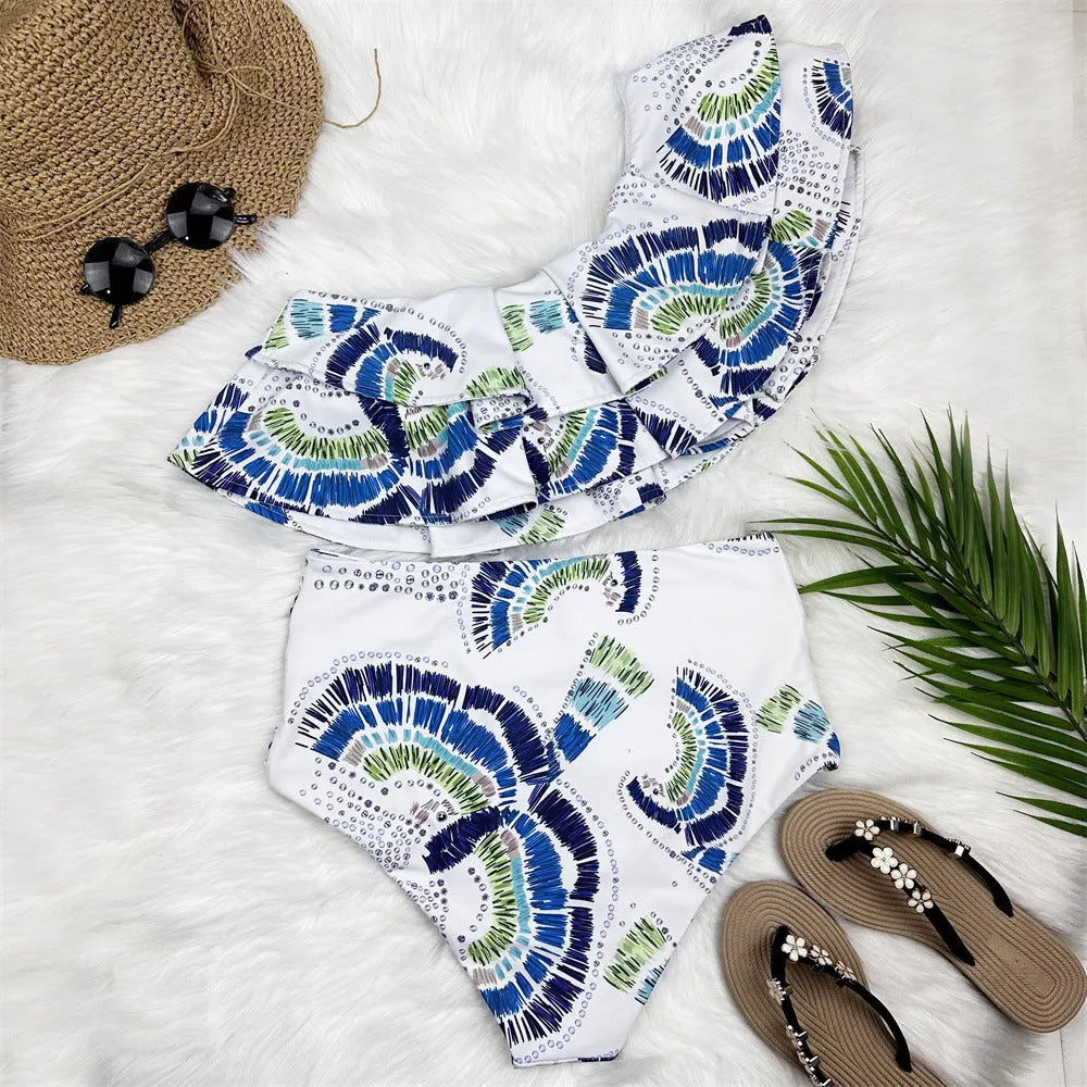 White women's one-shoulder swimsuit showing double-layer lotus leaf detail and a high side leg split.