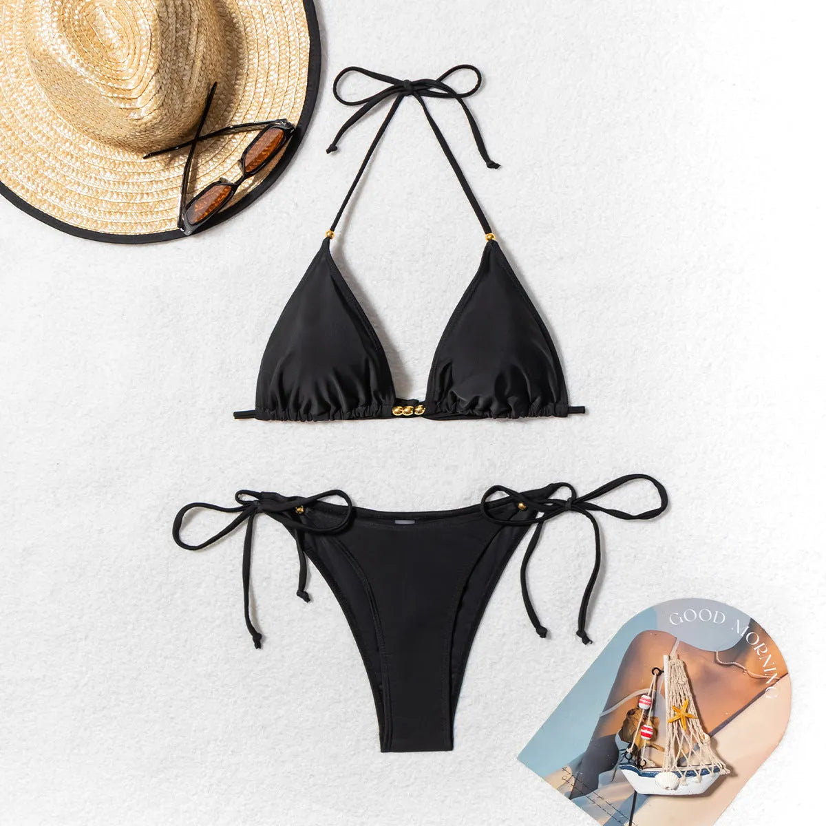 Black women's bikini swimsuit with metal bead decoration showing split-style two-piece design