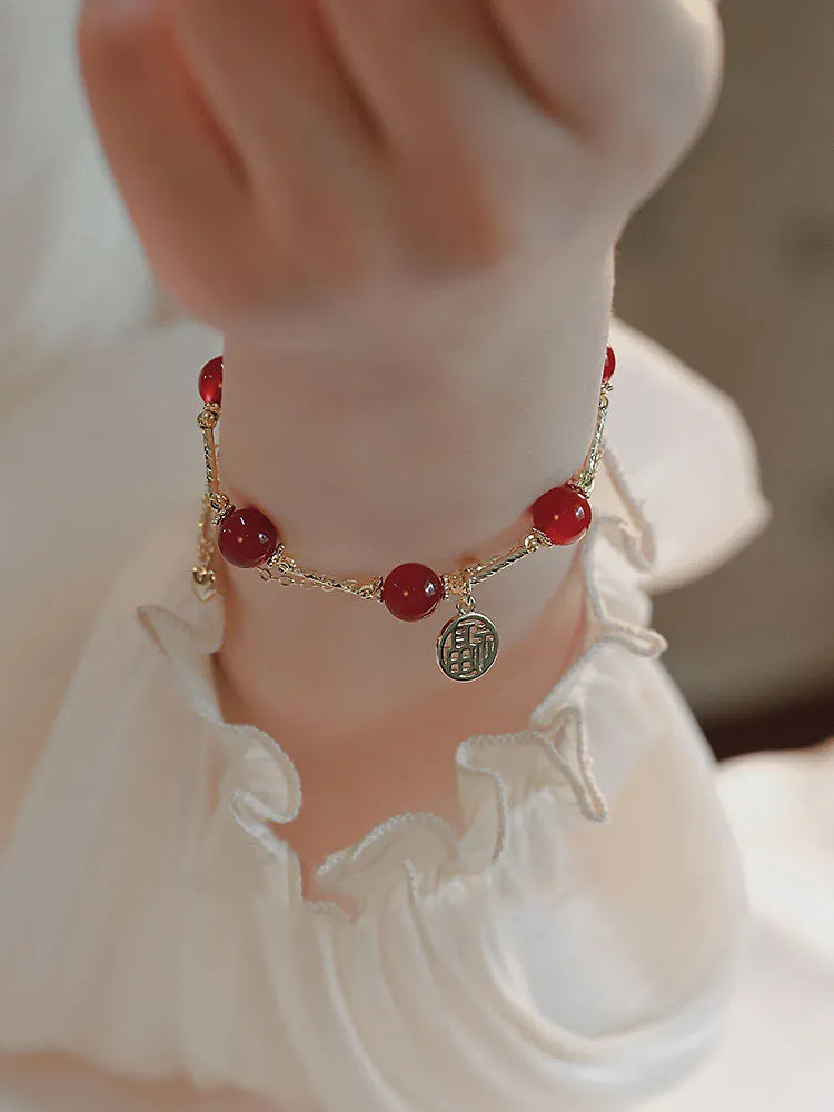 Red agate blessing card double-layer bracelet on display with alloy electroplated finish and chamfered square pattern