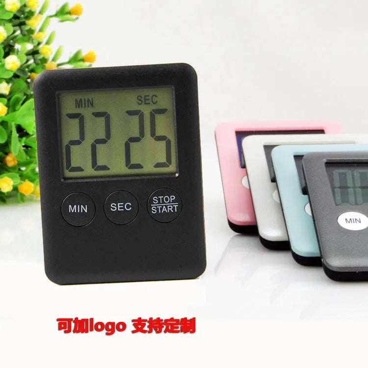 Black and white magnetic kitchen timer with large digital display on a refrigerator.