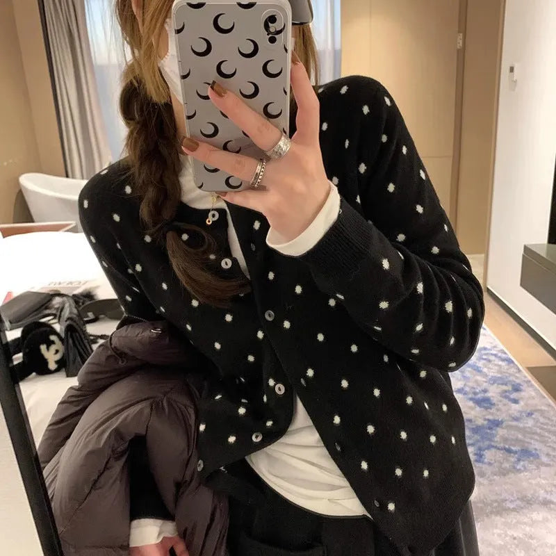 Women's loose fit grey knitted cardigan with crocheted flower details on the front.