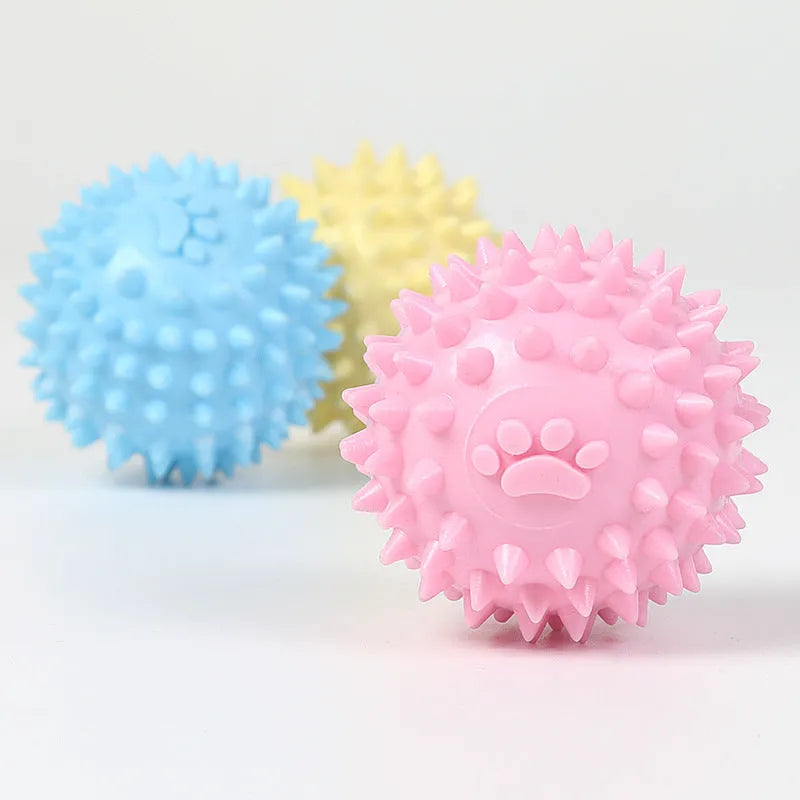 Blue, pink, or yellow TPR dog chewing ball with textured sides for tooth cleaning