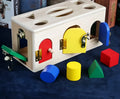Wooden educational shape lock box toy with 12 wooden shapes for preschool children.