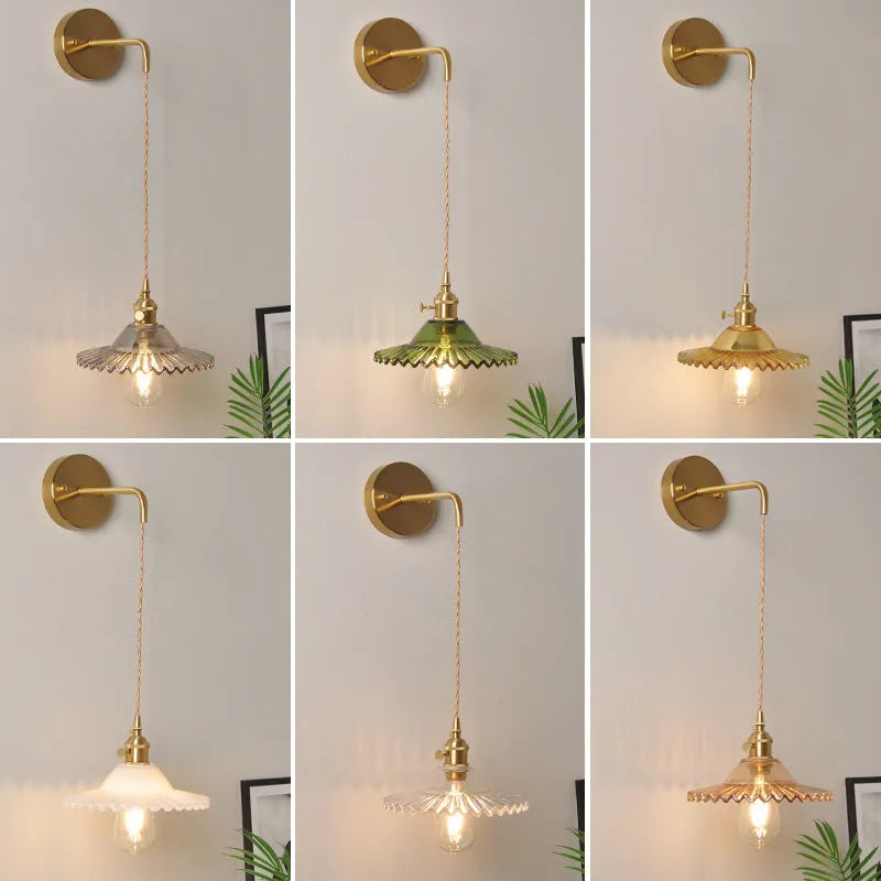 Retro brass copper lotus wall lamp with a glass shade in one of six colours, shown beside a bed.