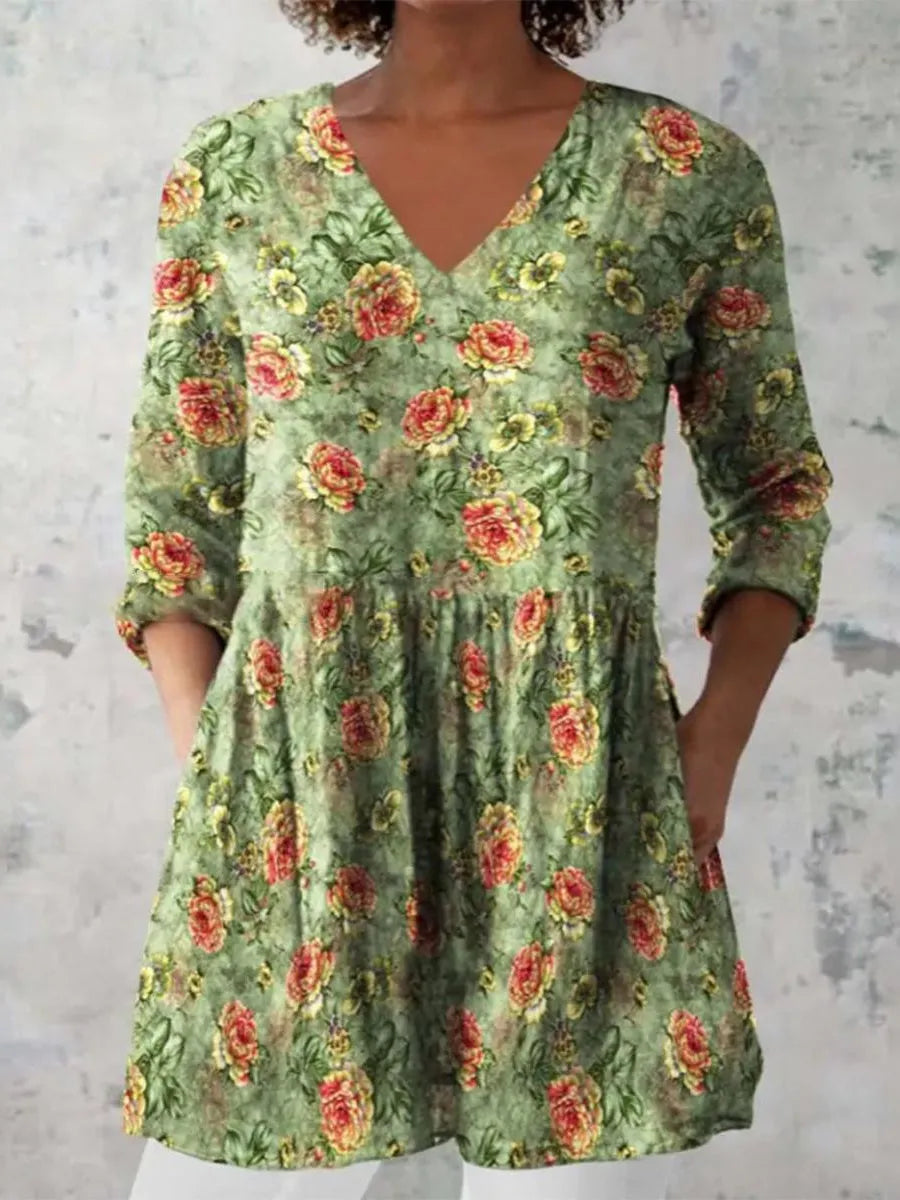 A woman modelling a printed, loose-fitting dress with a wide waist and three-quarter length sleeves.