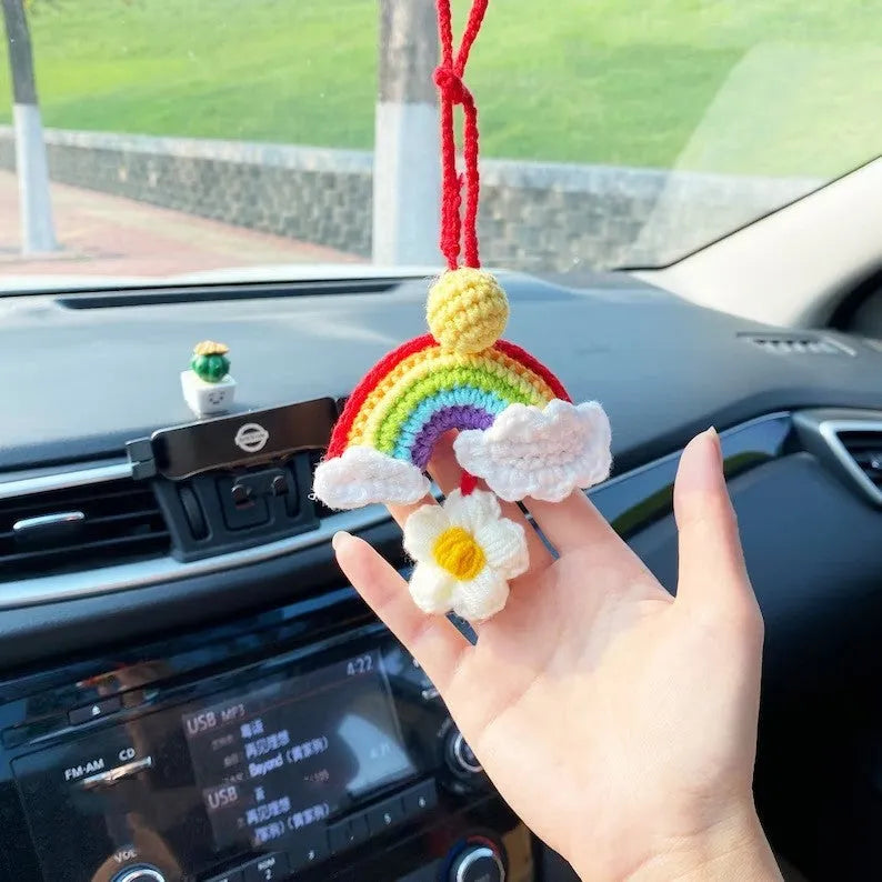 Handmade crocheted avocado-shaped rainbow flower car pendant hanging, shown in multiple colour options.