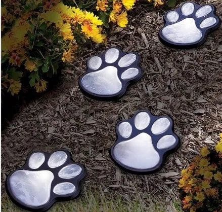 Black bear paw shaped solar garden lights with four paw prints connected to solar panel