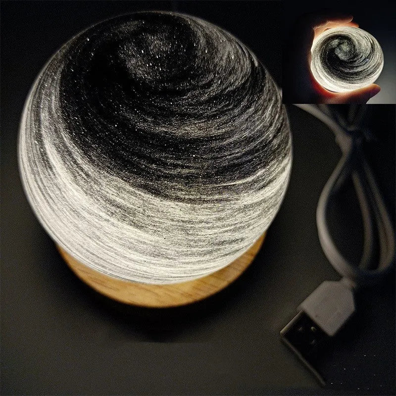 Modern simple planet-shaped USB night light on its base with soft glow.