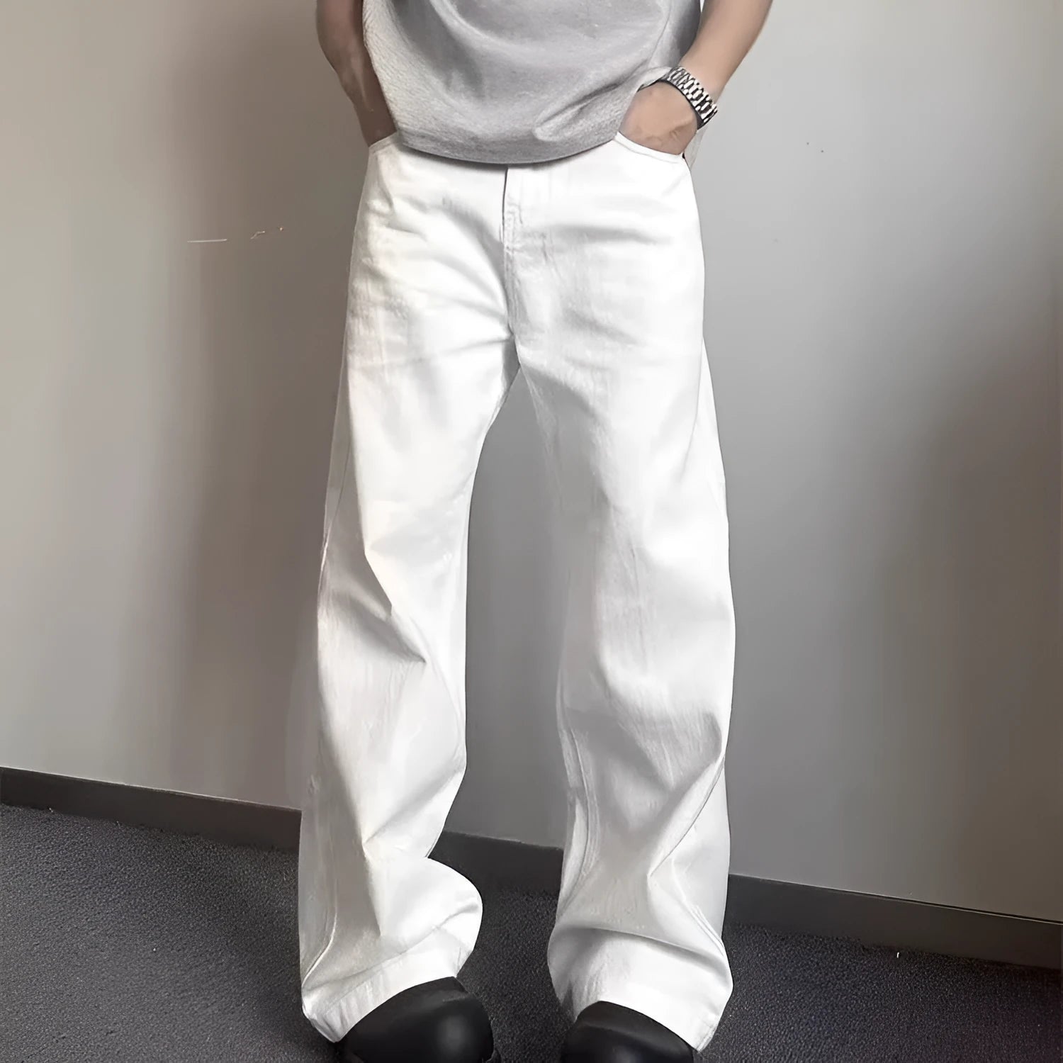 Man wearing loose straight-leg white denim jeans with a wide leg opening.