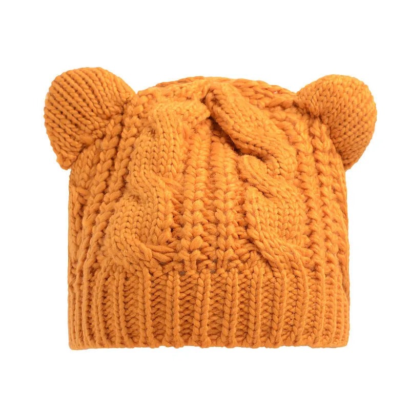 Handmade red knitted beanie with 3D cat ears on a white background