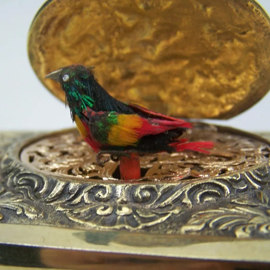 Gold alloy automatic pop-up bird box decoration on a tabletop, 10x6x4 cm