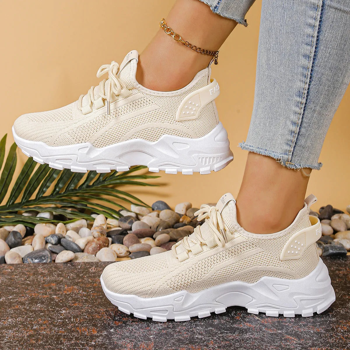Women's low-top white mesh sports shoes with platform sole and front laces on a grey background.