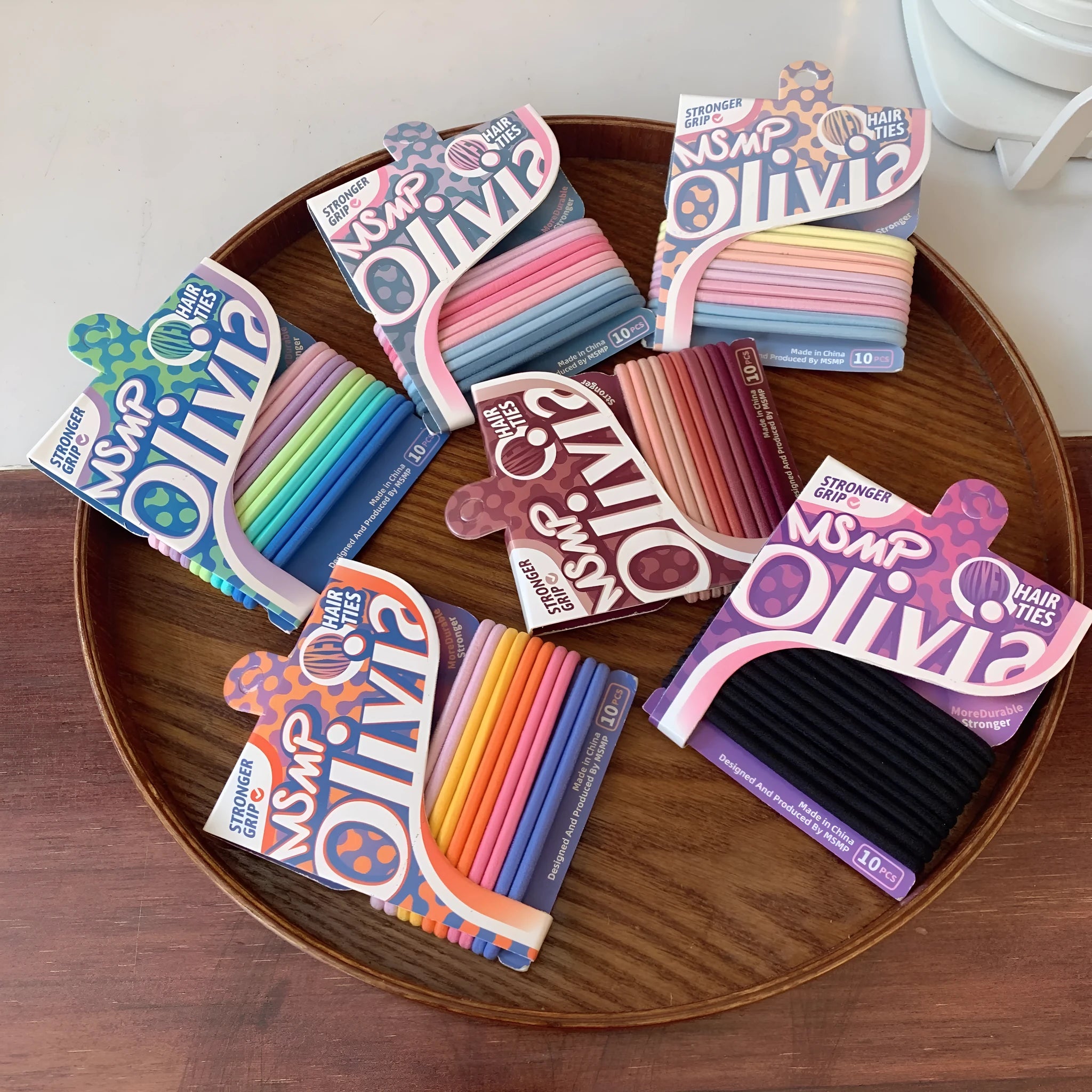 Assortment of candy-coloured braided elastic hair ties on a white background.