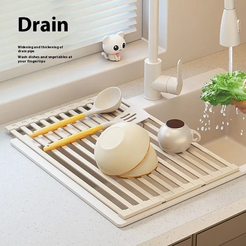 A milky white foldable stainless steel kitchen draining rack shown open on a countertop next to a sink.