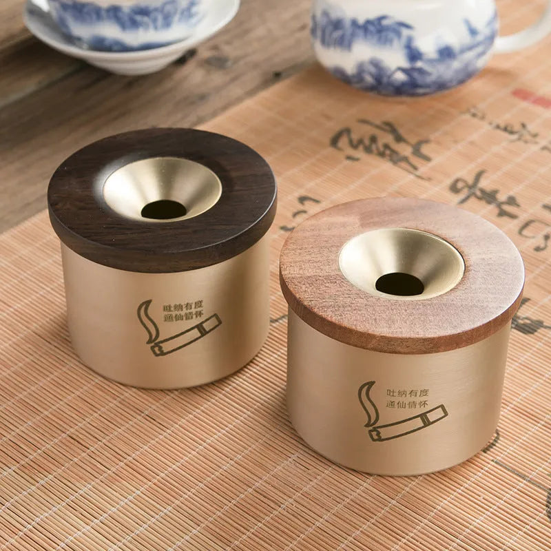 Brass ashtray with wooden lid showing central hole design for ash collection