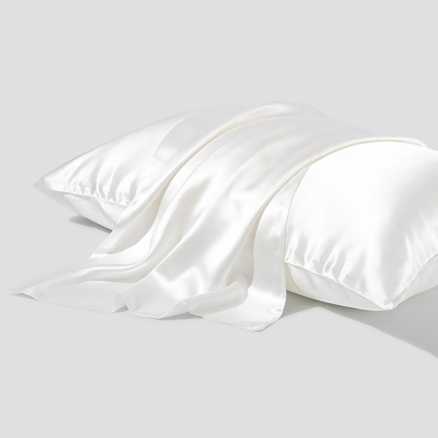 Dark grey envelope closure silk pillowcase on a bed.