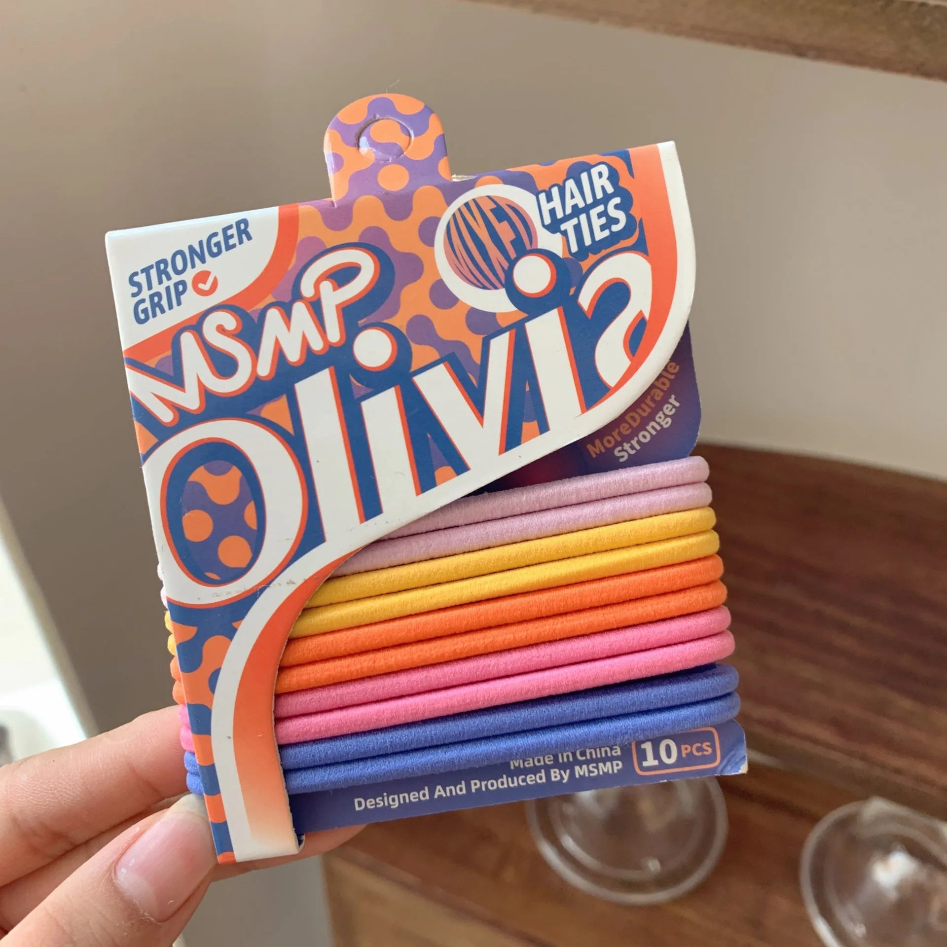 Assortment of candy-coloured braided elastic hair ties on a white background.