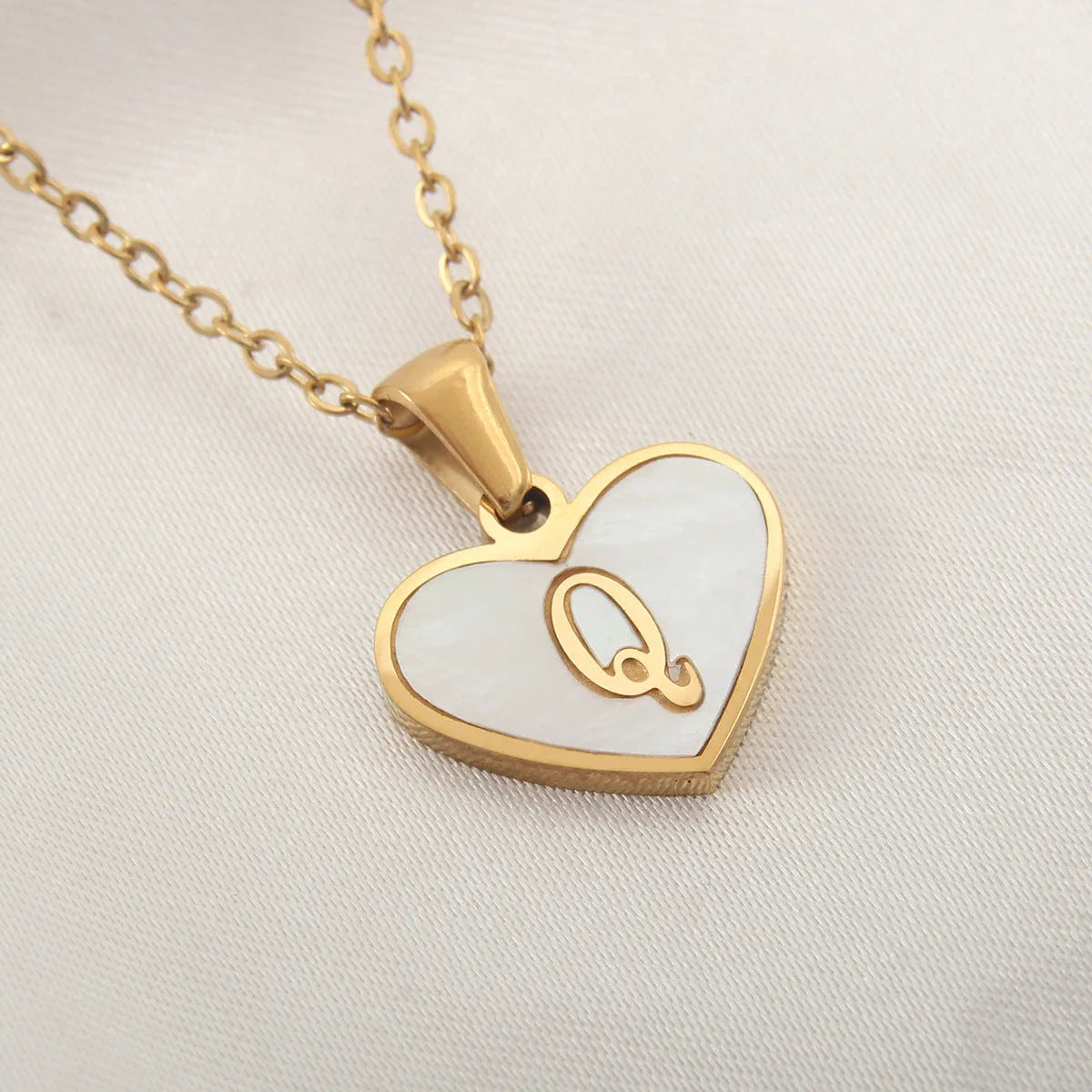 Gold heart necklace with white shell detail and personalised initial letter on adjustable chain