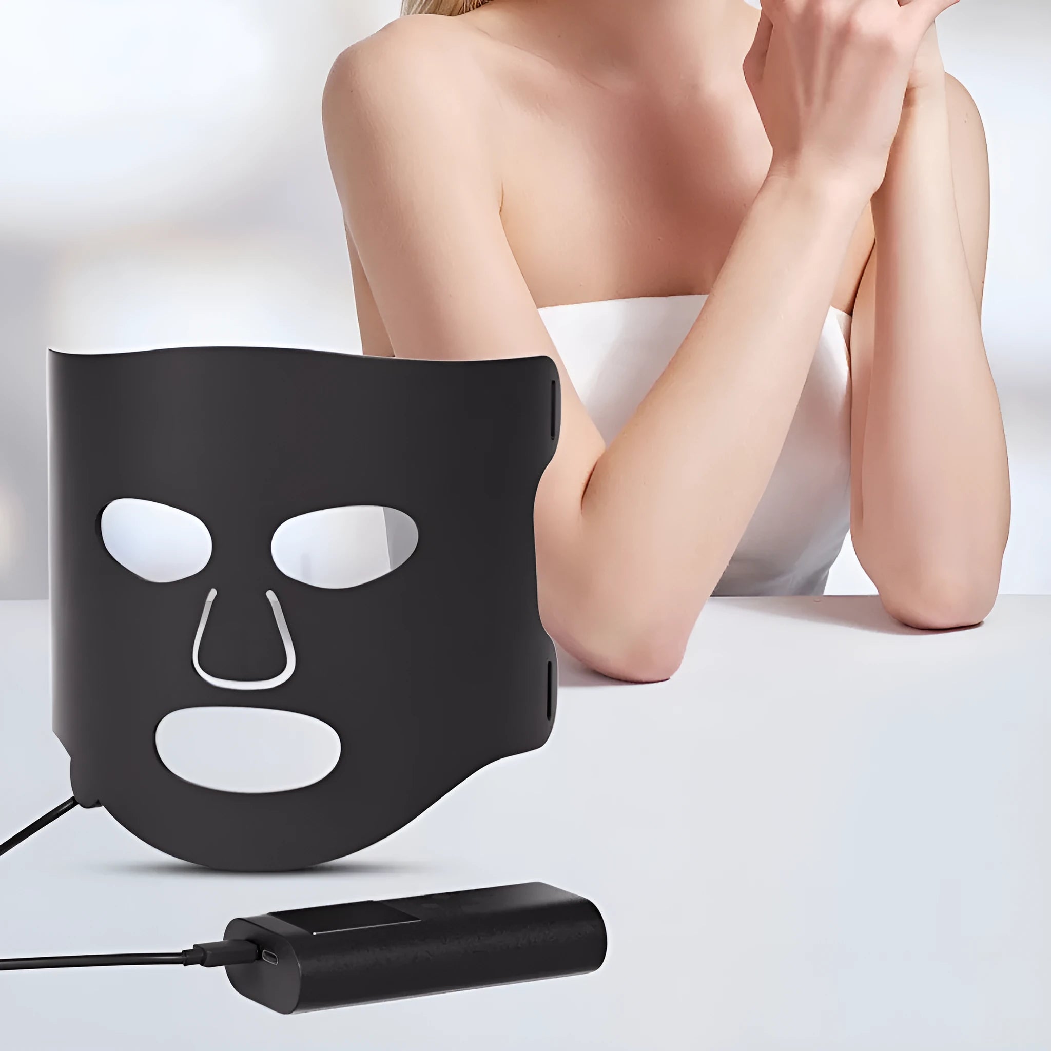 Black and gold LED phototherapy face mask with controller for home skin treatment.