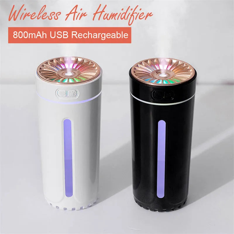 Black portable ultrasonic humidifier with colourful LED lights, shown next to a USB cable on a desktop.