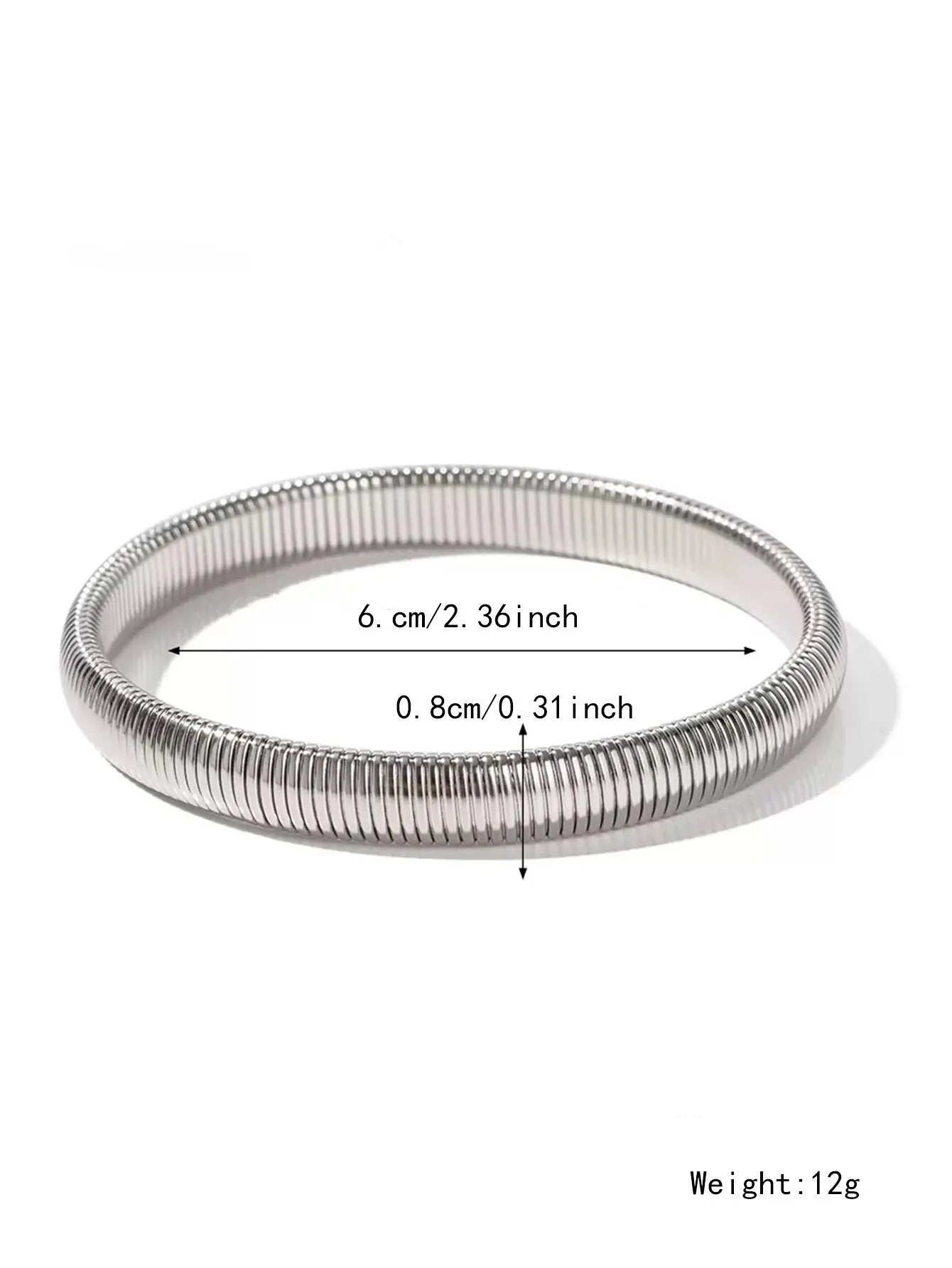 Close-up of a women's titanium steel bracelet with a vertical stripe ring pattern, shown in a gold tone finish on a wrist.