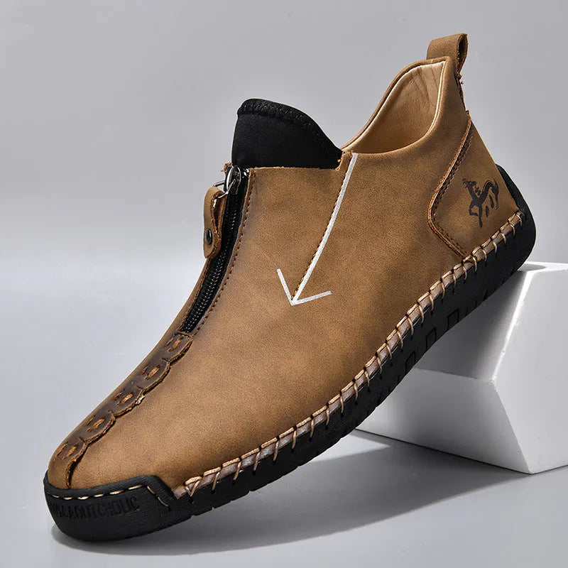 Men's brown leather boots with front zip closure and hand-stitched rubber soles