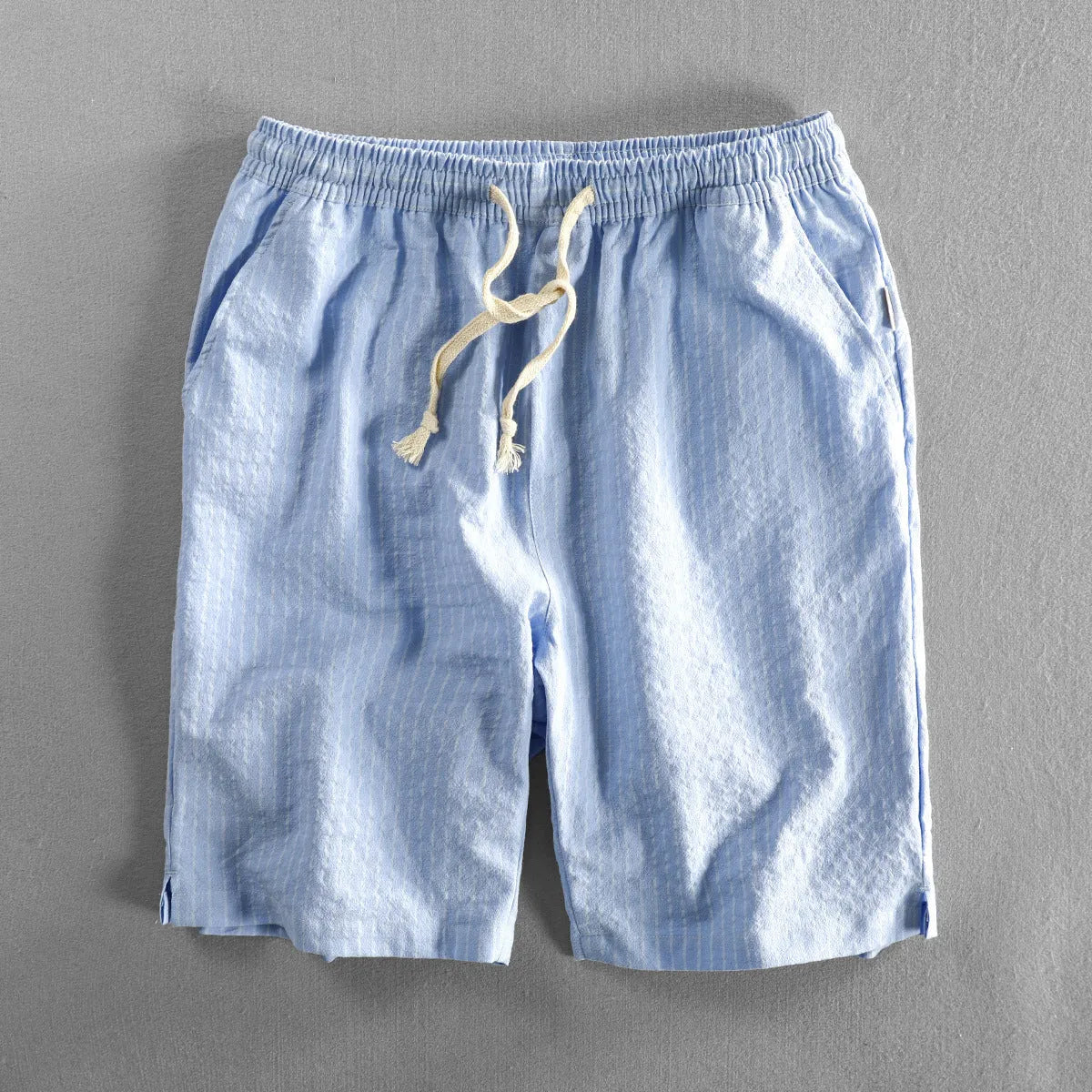 Men's striped cotton casual loose shorts on a hanger showing mid waist and shorts length.
